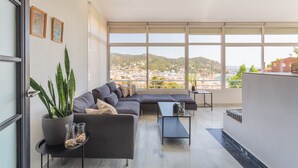 Un salon moderne avec un canapé, une table basse et une plante en pot.