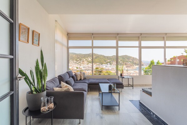 Un salon moderne avec un canapé, une table basse et une plante en pot.
