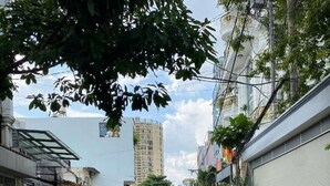A narrow street lined with residential buildings, some with balconies and potted plants. - Hotel Airport MTT (Ho Chi Minh City)