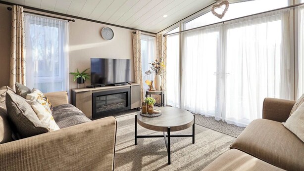 Una sala de estar con un sofá, una mesa de centro, un televisor y una chimenea.
