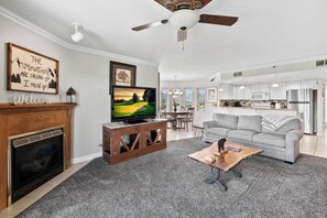 A living room with a fireplace, television, and a gray sofa.