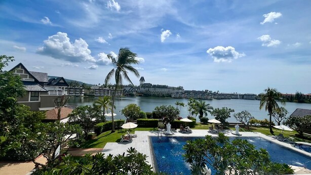 A resort with a swimming pool, palm trees, and a view of a body of water. - Luxurious Laguna Phuket Large 2-bedrooms 2 Bathrooms Ensuite With Large Pool (Choeng Thale)