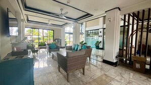 A spacious lobby with a reception desk, seating area, and a glass office. - Luxurious Laguna Phuket Large 2-bedrooms 2 Bathrooms Ensuite With Large Pool (Choeng Thale)