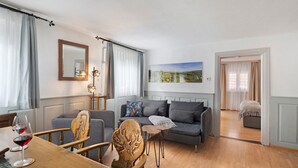 Un salón con una mesa de comedor de madera, un sofá gris y un cuadro en la pared.