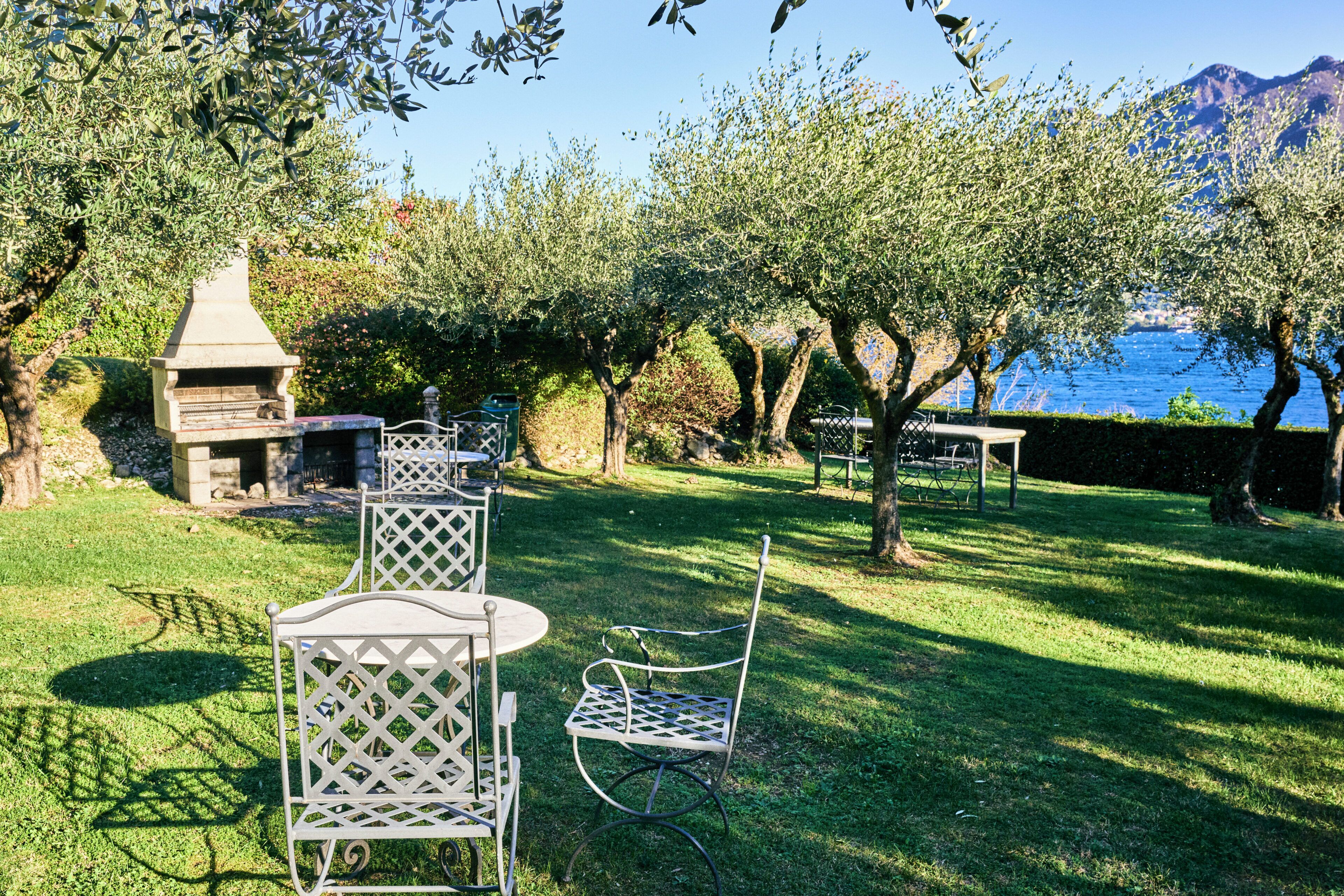 Un patio con mobiliario exterior, una parrilla y vista al mar.