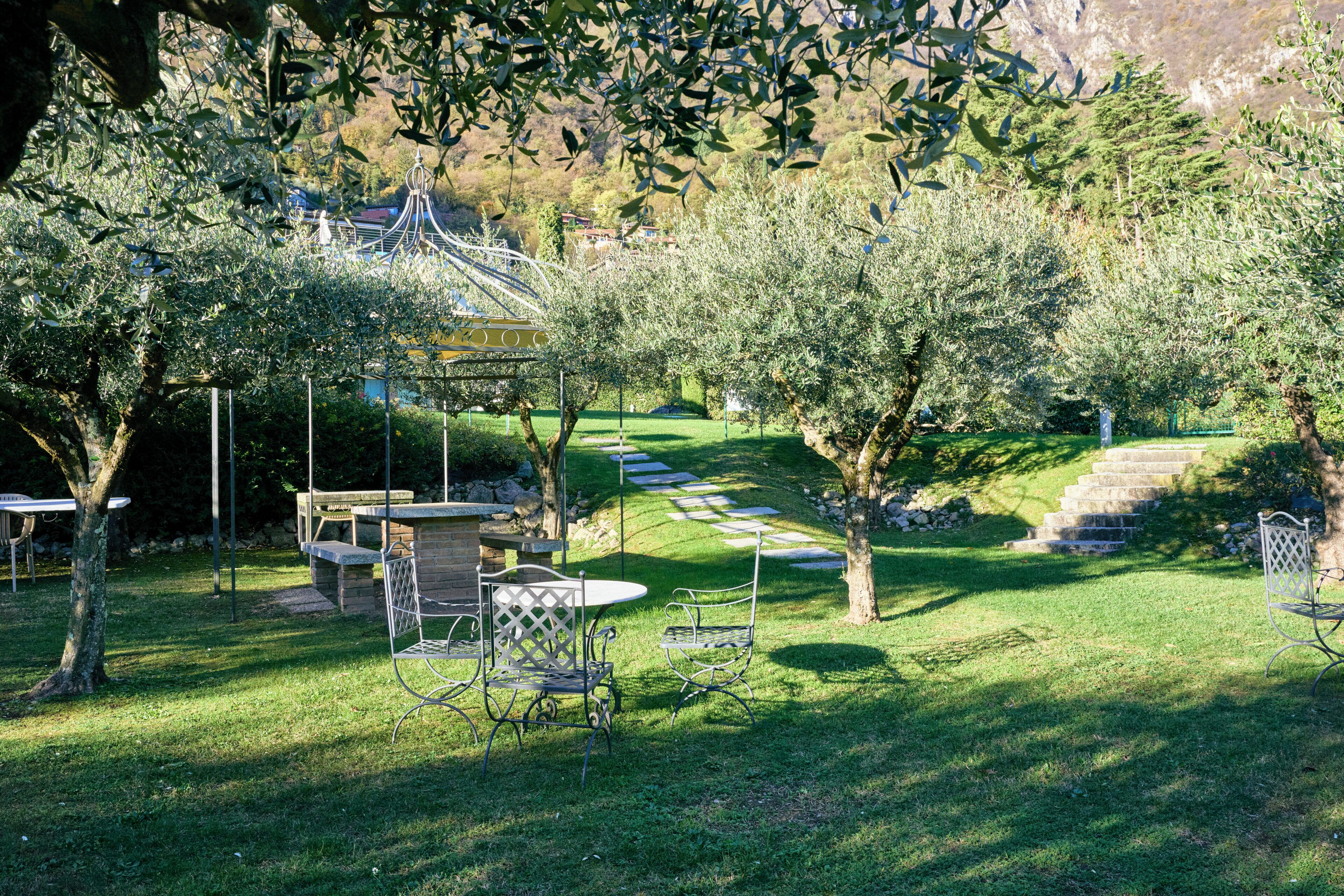 A garden with a gazebo, outdoor seating, and a stone staircase.