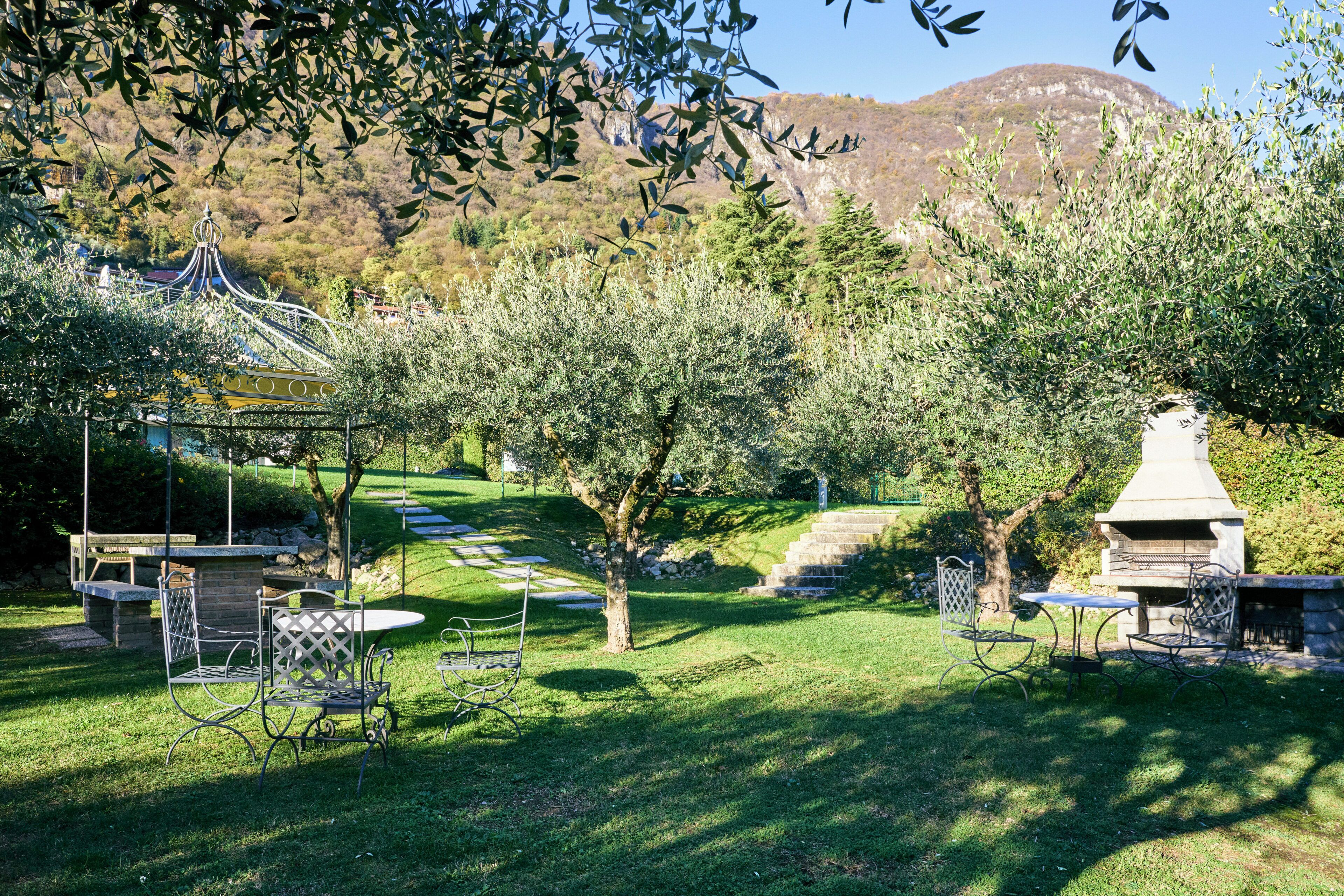 A garden with outdoor seating, a gazebo, and a barbecue area.
