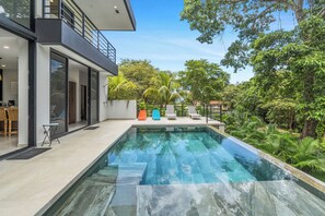 A modern house with a swimming pool, a balcony, and a lush garden. - Casa Nido - Modern Home - Private Pool - Beach Club Access (Playas Del Coco)