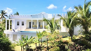 A white building with a pool, surrounded by tropical vegetation. - Castles in Paradise - by Zenbreak (Vieux Fort)