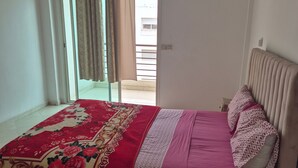 A bedroom with a bed, a window with curtains, an air conditioning unit, and a view of the outside. - Luxurious 3-bedroom Apartment in Historic Fès, Morocco (Fes)
