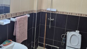 A bathroom with a sink, toilet, shower, and a towel rack. - Luxurious 3-bedroom Apartment in Historic Fès, Morocco (Fes)