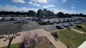 A parking lot with RVs and cars, surrounded by trees and a clear sky. - Appartement lumineux avec terrasse – Arcachon, Ville d’Automne (Arcachon)