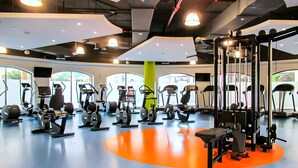 Ett gym med olika typer av träningsutrustning, inklusive löpband, crosstrainers och styrketräningsmaskiner.