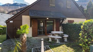 A house with a sloped roof, wooden shutters, a patio with a table and benches, and a mountain backdrop. - Chalet with terrace - 5 guests quiet Cauterets (Cauterets)