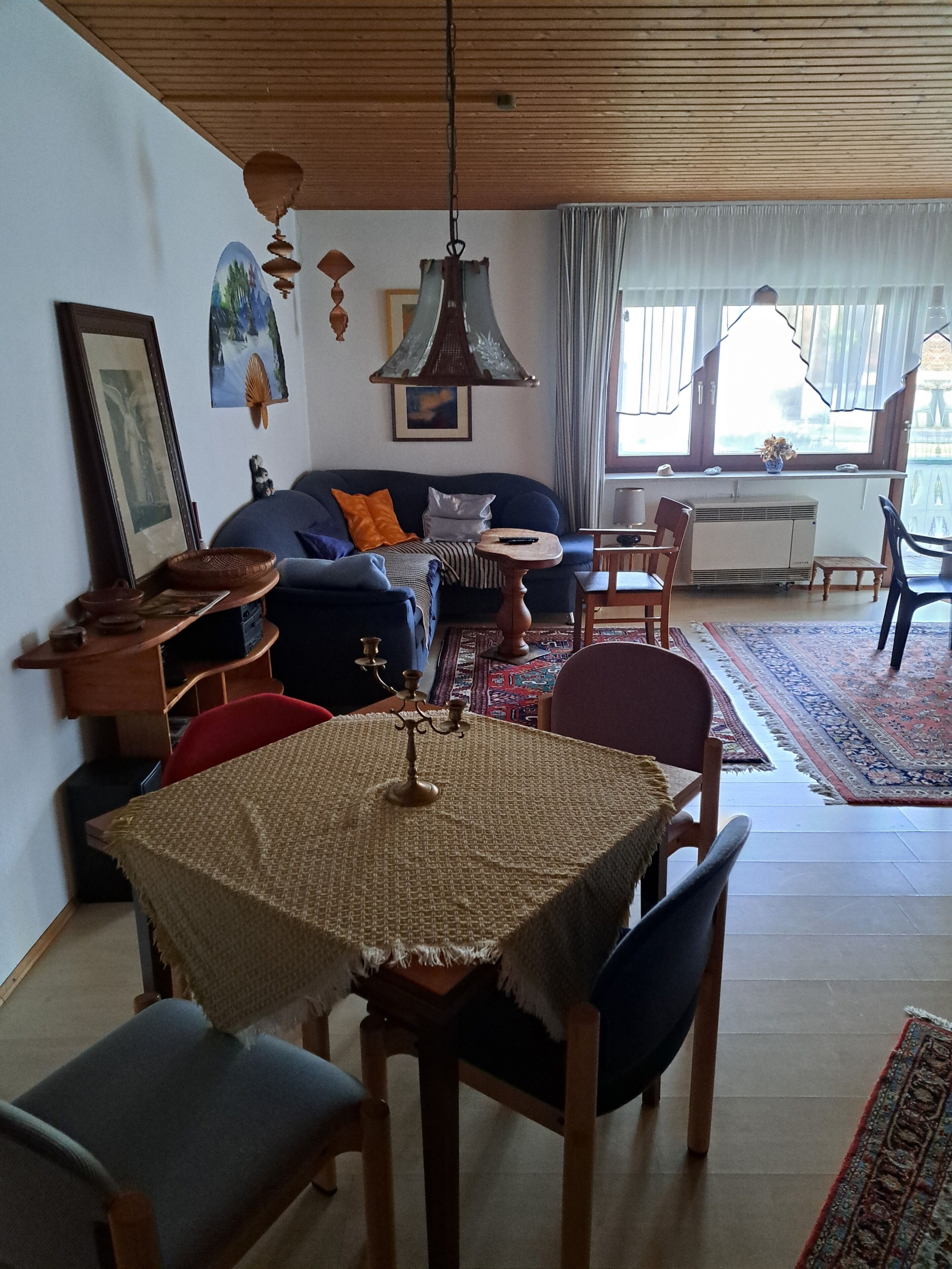 Un comedor con una mesa, sillas y un candelabro.