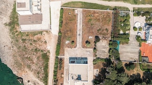 An aerial view of a coastal property with a large building, a swimming pool, and a tennis court. - Exclusive beachfront villa, 6 bedrooms, garden, Monopoli (Monopoli)