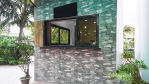 A building with a stone facade, a window, and potted plants. - Townhouse OAK Howrah Oak Belilious Park (Howrah)