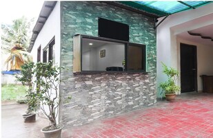 A building with a stone facade, a window, and potted plants.