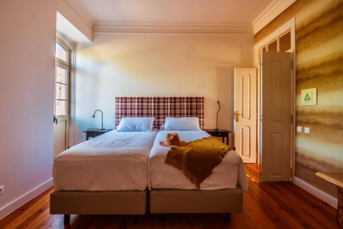 A double bed with a plaid headboard, a bedside table, and a nightstand.