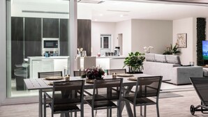 Una cocina moderna con microondas y una zona de comedor con una mesa dispuesta para cuatro.