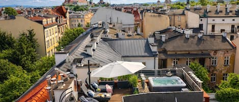 Una terraza en la azotea con un jacuzzi, zona de estar y vistas a la ciudad.