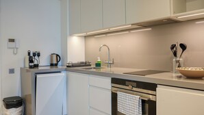 Een moderne keuken met een vaatwasser, oven en een koffieapparaat.