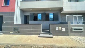 A modern two-story building with a flat roof, large windows, and a gated entrance. - Beachfront Bliss in Praia Baixo – 1Min Walk to Sea (Praia Baixo)