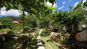 Un sendero atraviesa un jardín exuberante con una casa al fondo.