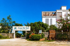 Een bordje voor Casa De Sol met uitzicht op de ingang van het resort en de aanliggende groenvoorziening.