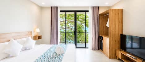 A hotel room with a bed, a TV, a wooden cabinet, and a balcony with curtains.