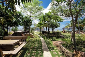 A pathway leading to a beach area with wooden benches and a view of the sea. - Casa De Sol - Wuwei Retreat (Phu Quoc)
