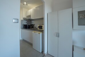 A modern kitchen with white cabinets, a built-in microwave, and a dishwasher. - Sea view studio with private terrace & pool - Top floor on the Riviera (Villeneuve-Loubet)