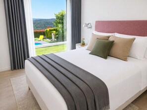 A bedroom with a large bed, a view of a pool and greenery, and a lamp on the nightstand. - An oasis in Santiago, with a pool, garden, and bus to the city center (Teo)