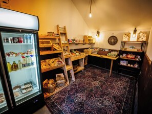 Une chambre équipée d’un réfrigérateur rempli de boissons, d’un four à micro-ondes et de diverses provisions disposées sur des étagères.