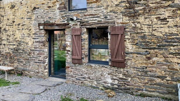A stone building with a door, two windows with shutters, and a small porch area. - Gite modulable "Chez Yvette", 65m2 au calme à 800 mètres du centre ville (La Gacilly)