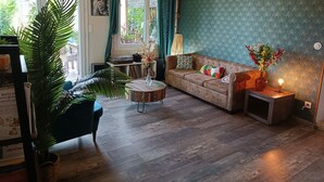 A living room with a sofa, a coffee table, a lamp, and a potted plant. - Magnificent villa with breathtaking views, swimming pool, Jacuzzi 35min from the beaches. (Bédarieux)