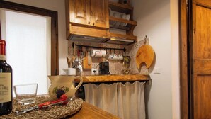 A kitchen with wooden cabinets, a wooden countertop, and a woven placemat.