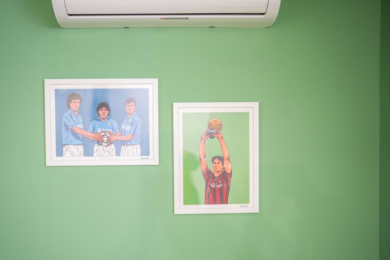 Two framed sports photographs on a green wall.