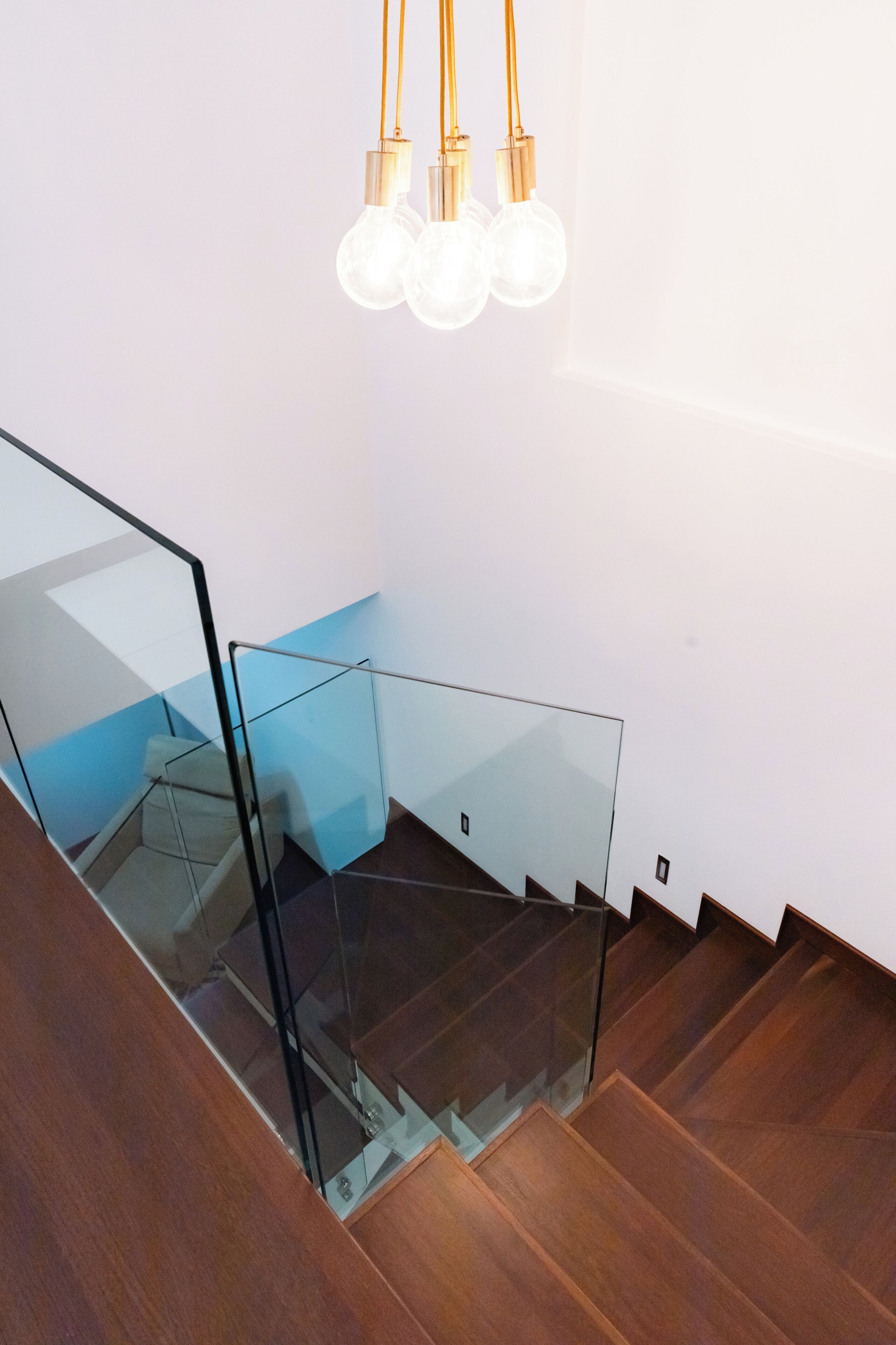 A staircase with glass railings and wooden steps.