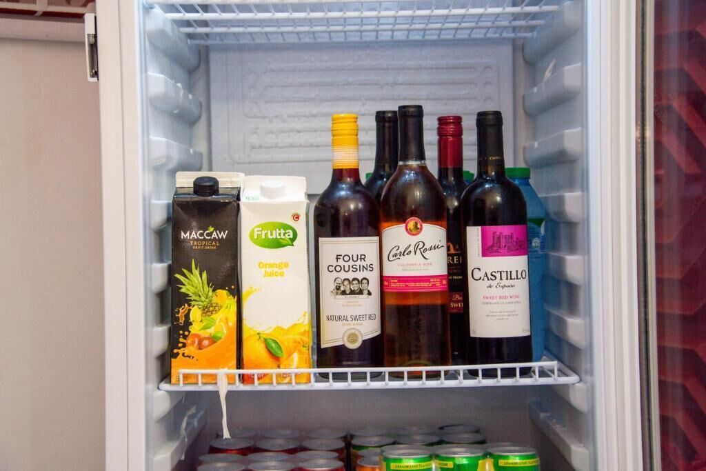 A refrigerator containing various beverages including juice and wine.