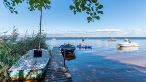 Une jetée en bois s’étendant dans une étendue d’eau calme, avec des bateaux amarrés à son extrémité.
