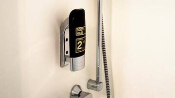 Eine Dusche mit Handbrause, Wandarmatur und digitaler Bedieneinheit.