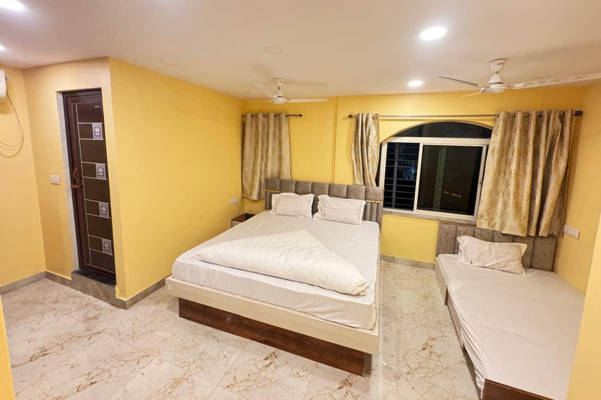 Habitación de hotel con dos camas, una ventana, cortinas, una puerta y ventiladores de techo.