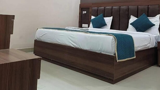 A modern hotel room with a bed, a desk, and a ceiling fan.