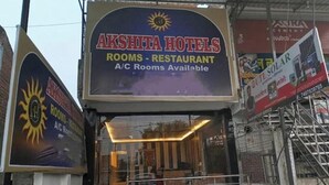 A hotel sign with 'AKSHITA HOTELS' and 'ROOMS - RESTAURANT' indicating available A/C rooms.