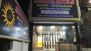 A hotel entrance with a sign for Akshita Hotels, indicating A/C rooms and a restaurant are available.