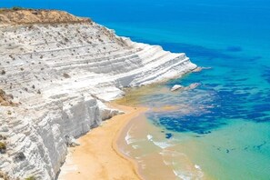 Un paysage côtier caractérisé par de hautes falaises blanches et une plage de sable.