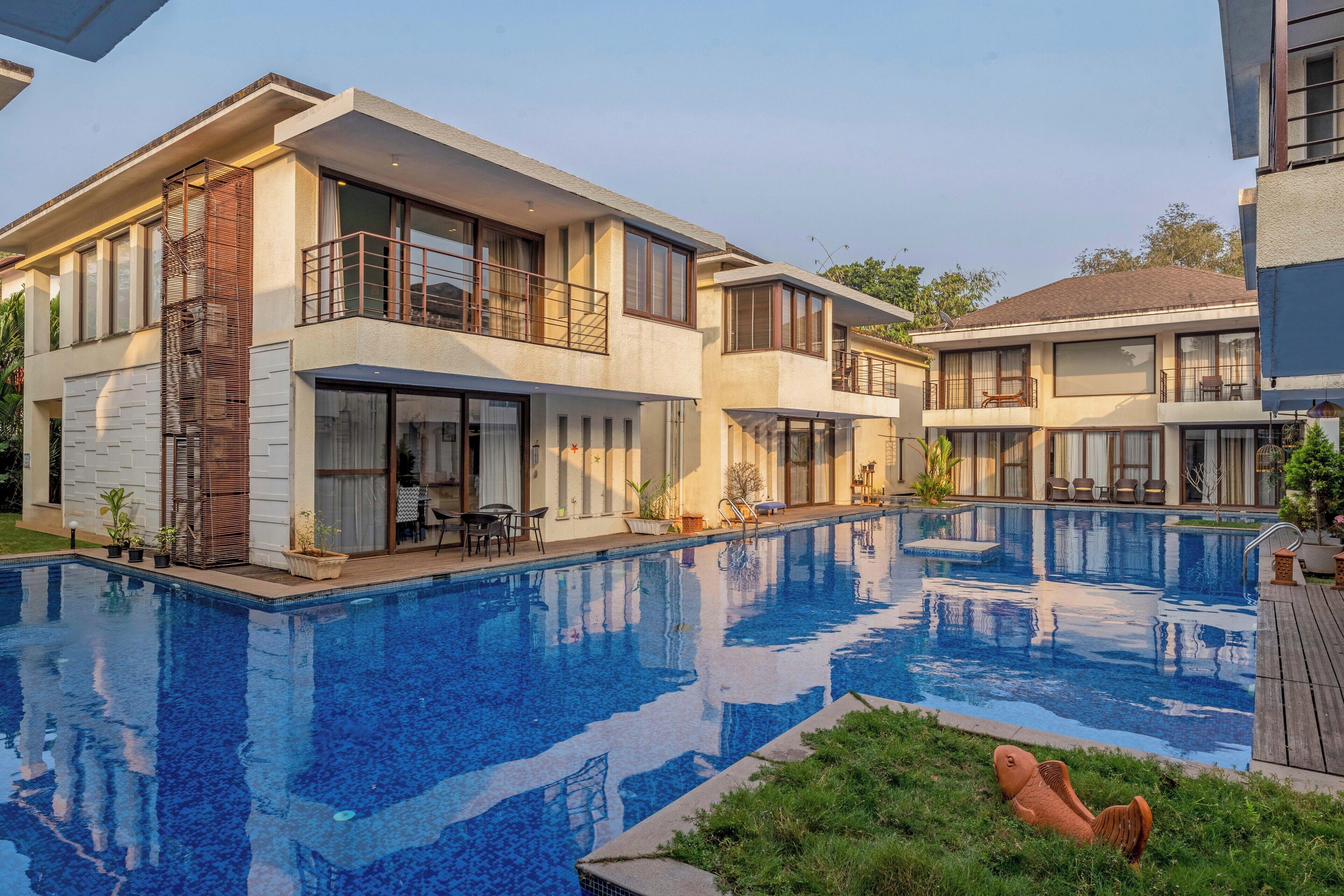Ein modernes Wohngebäude mit Schwimmbad, großen Fenstern und einem Balkon.