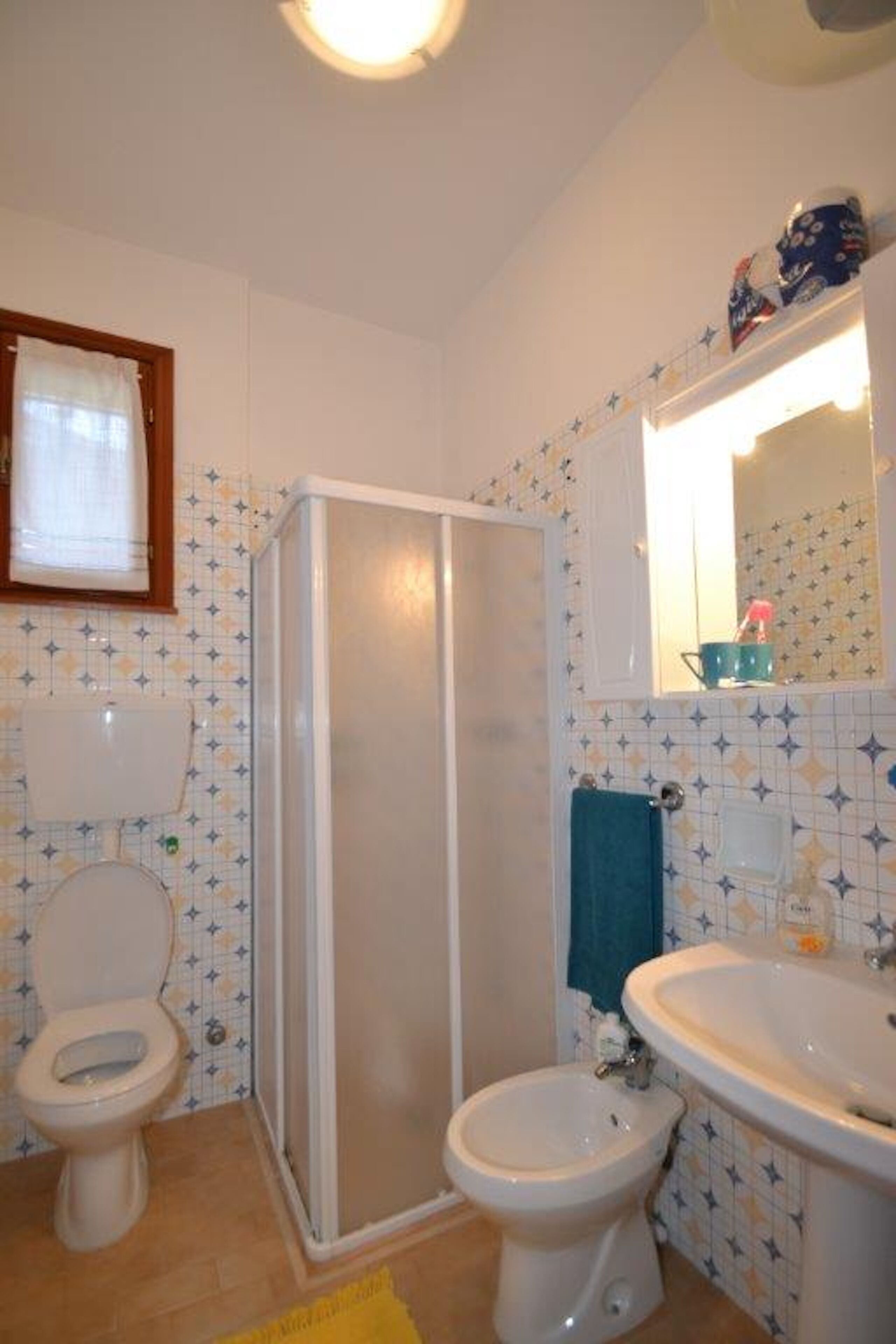 Ein Badezimmer mit Toilette, Bidet, Dusche und Waschbecken.