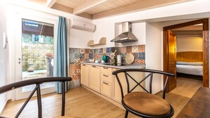 A compact kitchen with a dining area, a wooden ceiling, and a view of the outside. - Le Vigne - Appartamento Giardini (Bolsena)